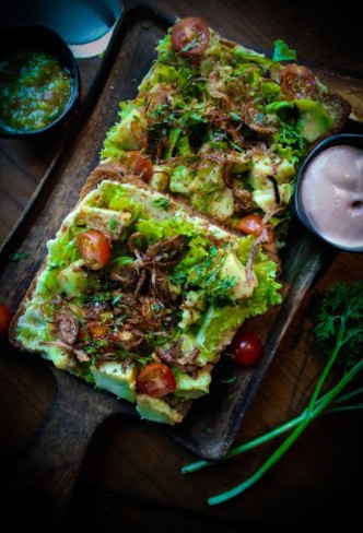 כריך כפרי עם אבוקדו, בצל מטוגן, עגבניות שרי, חסה וצ'ימיצ'ורי